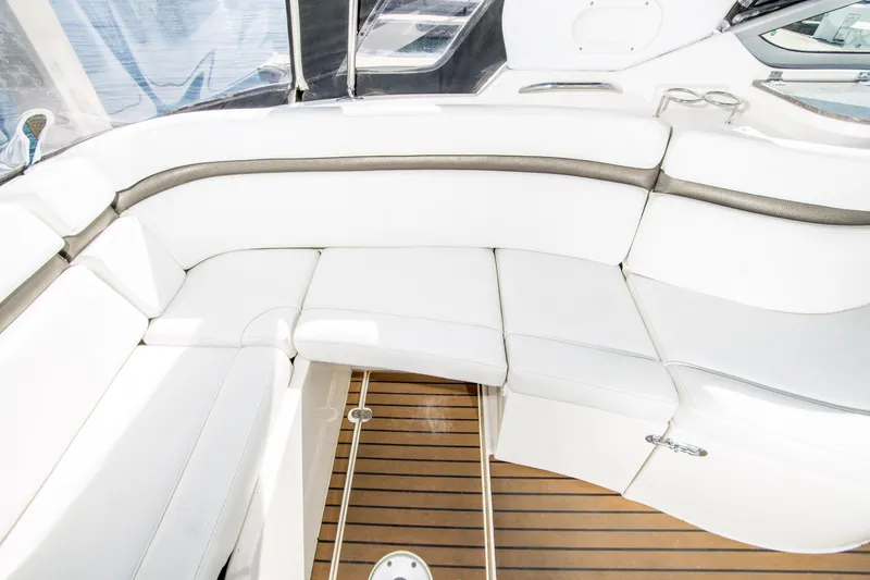 Slide: The Image of 2012 Rinker 310 Express Cruiser interior with white seating and wooden flooring. - 9