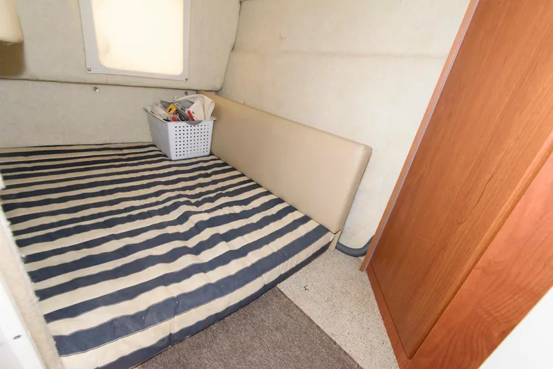 Slide: The Image of 2004 Bayliner 289 Classic cabin interior with striped bedding and storage basket. - 11