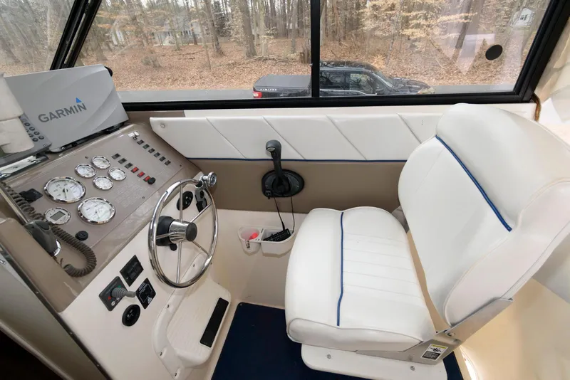 Slide: The Image of 2004 Bayliner 289 Classic helm with Garmin navigation, white captain's chair, and control panel. - 4