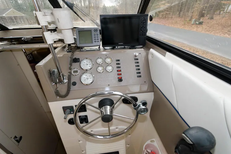 Slide: The Image of 2004 Bayliner 289 Classic boat dashboard with steering wheel, gauges, and navigation equipment. - 5