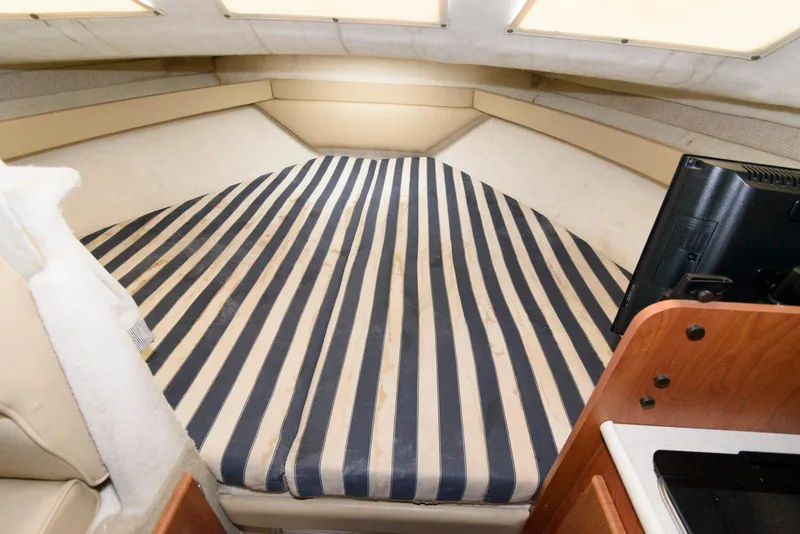 Slide: The Image of 2004 Bayliner 289 Classic cabin interior with striped bedding and modern amenities. - 7