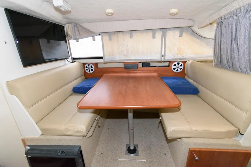 Slide: The Image of Interior of 2004 Bayliner 289 Classic boat with dining area and beige seating. - 8