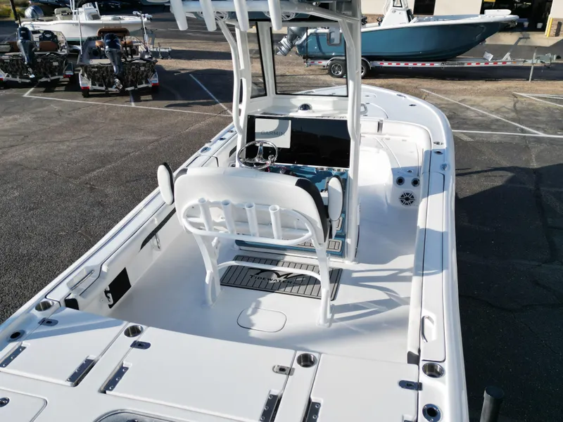 Slide: The Image of 2025 Tidewater 2500CB boat interior, featuring helm and seating, parked in a marina. - 18