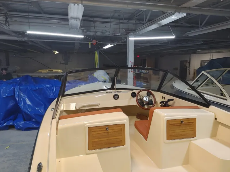 Slide: The Image of 2023 Rossiter Runabout 17 boat interior in a garage setting. - 2