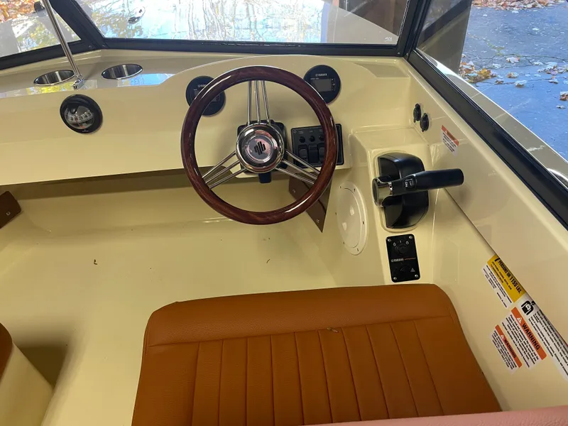 Slide: The Image of 2023 Rossiter Runabout 17 interior with steering wheel and brown seating. - 5