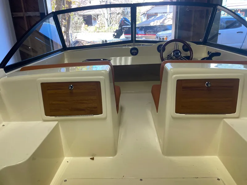 Slide: The Image of 2023 Rossiter Runabout 17 interior with dual seats and wooden dashboard accents. - 7