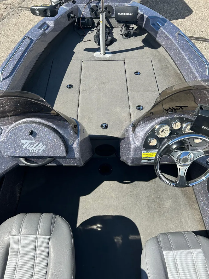 Slide: The Image of 2014 Tuffy 1760 Osprey boat interior with steering wheel and dashboard controls. - 21