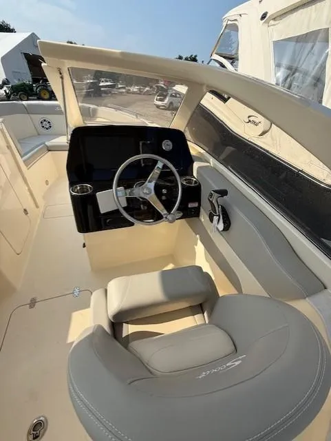 Slide: The Image of 2025 Scout 240 Dorado boat interior with steering wheel and seating. - 12