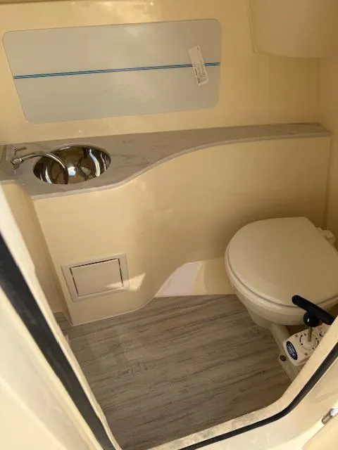Slide: The Image of 2025 Scout 240 Dorado boat bathroom with sink and toilet, featuring modern design. - 13