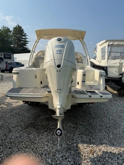 Slide: The Image of 2025 Scout 240 Dorado boat with Yamaha 300 V6 engine, parked on gravel. - 2