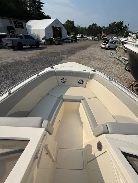 Slide: The Image of 2025 Scout 240 Dorado boat interior with seating, parked outdoors. - 5