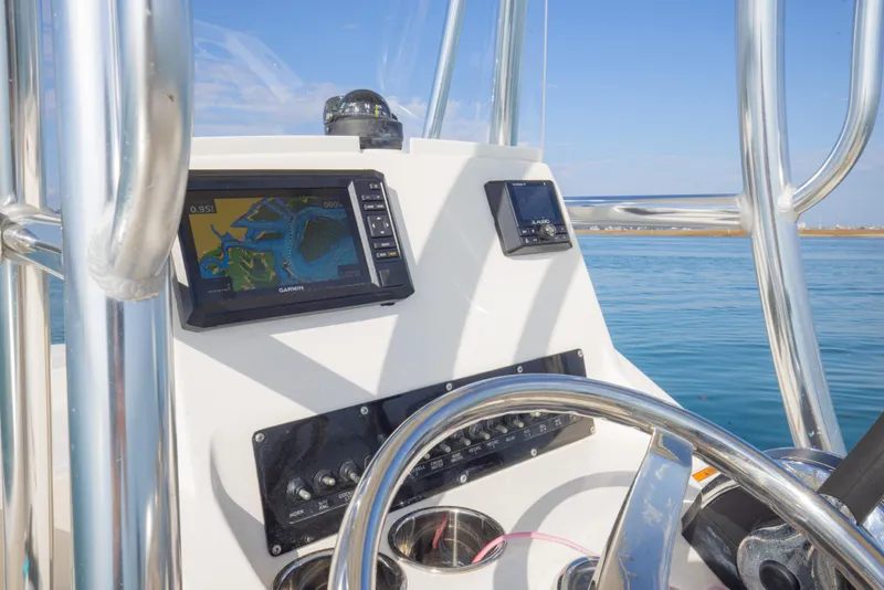 Slide: The Image of Boat dashboard with navigation screens and controls, Pathfinder 2005 TRS, 2022 model, on open water. - 20