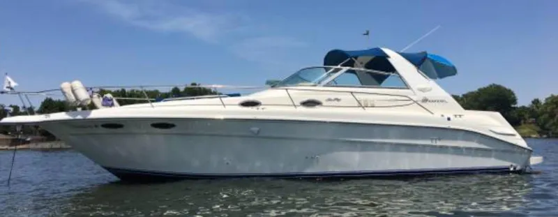 The Image of 1996 Sea Ray 330 Sundancer boat on water, blue canopy, clear sky. - 0