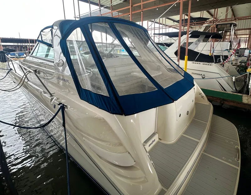 Slide: The Image of 1996 Sea Ray 330 Sundancer boat docked in marina, featuring blue canopy and spacious deck. - 11