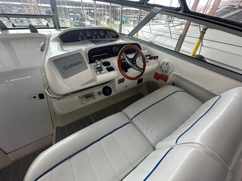 Slide: The Image of 1996 Sea Ray 330 Sundancer helm with Garmin navigation, featuring white seating and wood-accented steering wheel. - 13