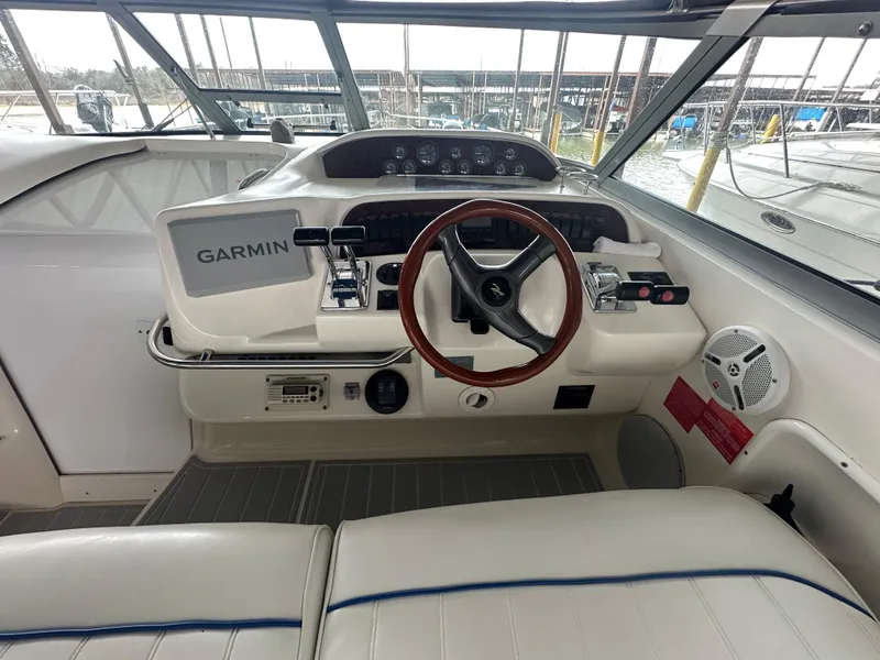 Slide: The Image of 1996 Sea Ray 330 Sundancer helm with Garmin navigation, wooden steering wheel, and white seating. - 14