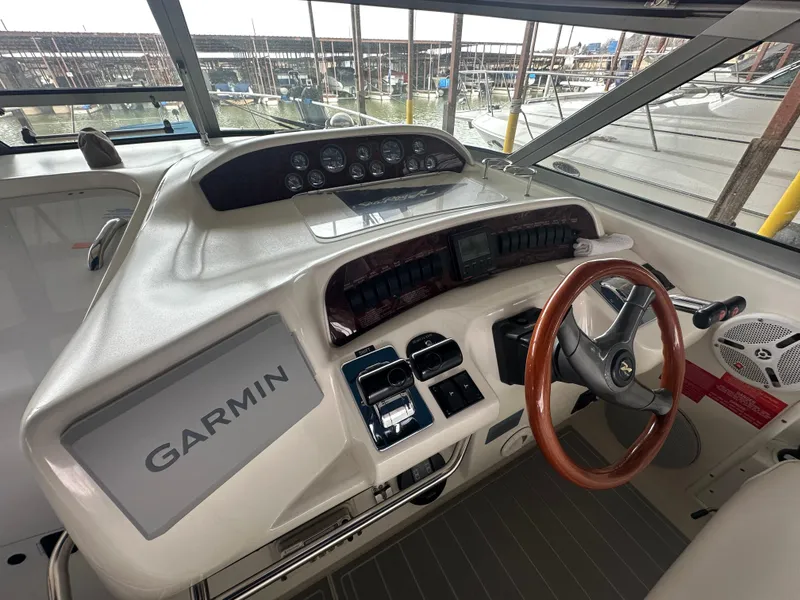 Slide: The Image of 1996 Sea Ray 330 Sundancer helm with Garmin navigation and wooden steering wheel. - 22