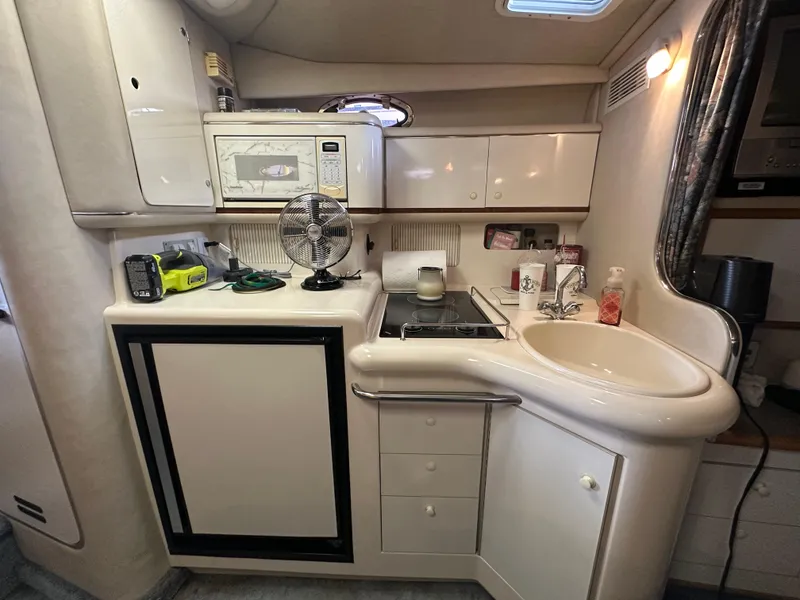 Slide: The Image of 1996 Sea Ray 330 Sundancer cabin kitchen with microwave, sink, and storage cabinets. - 35