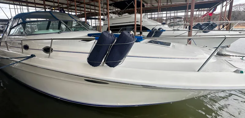 Slide: The Image of 1996 Sea Ray 330 Sundancer docked, featuring sleek design and protective fenders. - 8