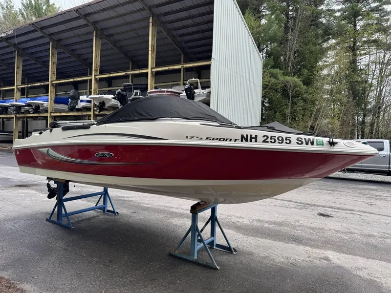 Slide: The Image of 2009 Sea Ray 175 Sport boat on stands, red and white, stored outdoors. - 3