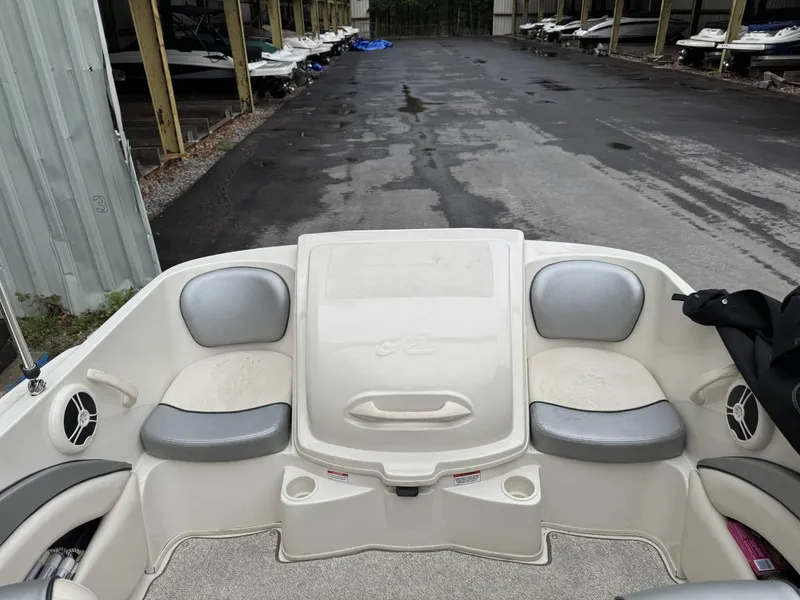 Slide: The Image of 2009 Sea Ray 175 Sport boat interior with seating and storage, parked in a marina. - 6