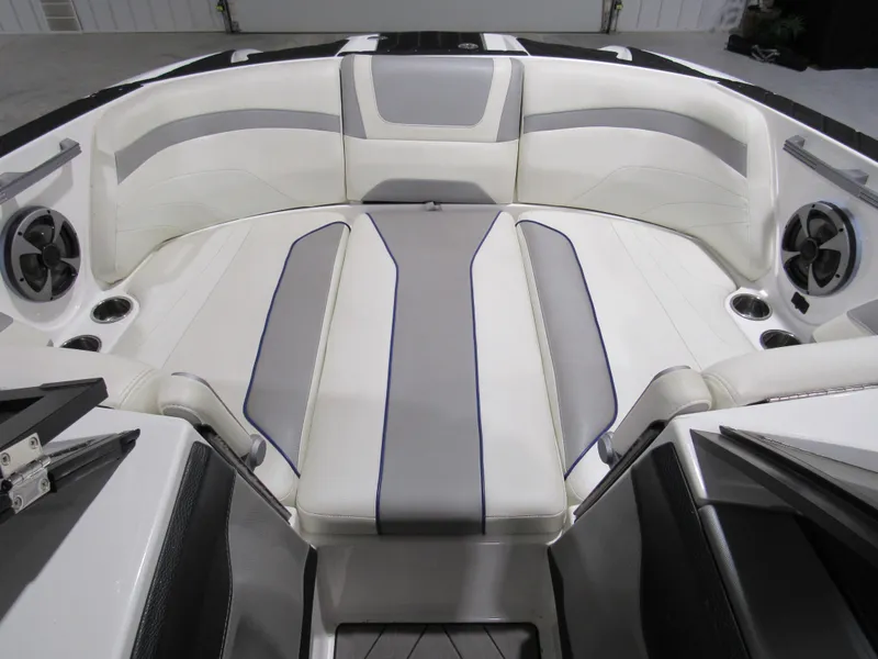 Slide: The Image of 2017 Malibu 22 MXZ boat interior with white and gray seating and built-in speakers. - 10