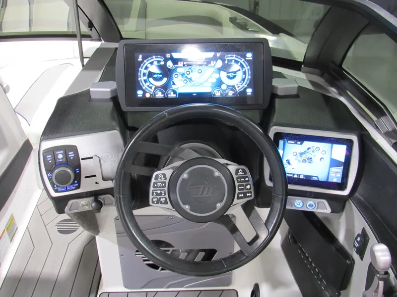 Slide: The Image of 2017 Malibu 22 MXZ boat dashboard with advanced digital controls and steering wheel. - 8
