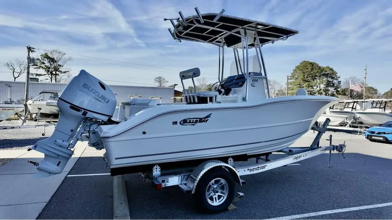 Slide: The Image of 2025 Bulls Bay 200CC boat on trailer, featuring Suzuki outboard motor, parked outdoors. - 1