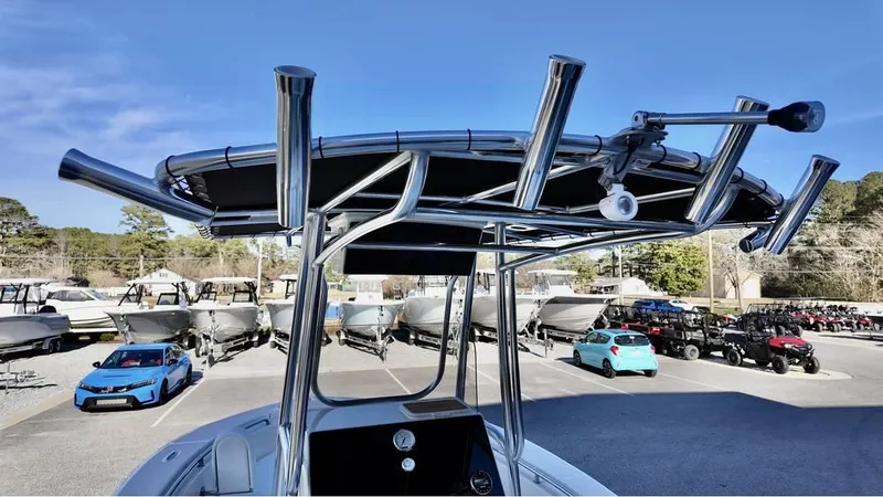 Slide: The Image of 2025 Bulls Bay 200CC boat with T-top and rod holders in a marina setting. - 10