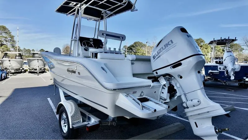 Slide: The Image of 2025 Bulls Bay 200CC boat with Suzuki outboard motor in a parking lot. - 2