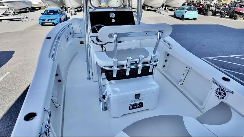 Slide: The Image of 2025 Bulls Bay 200CC boat interior with seating and storage, parked in a marina. - 9