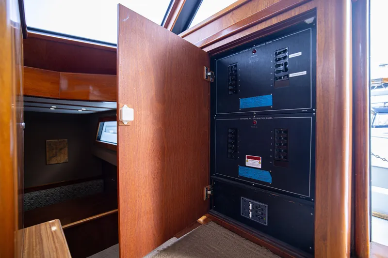 Slide: The Image of Electrical panel inside a 1980 Hatteras 53 Motor Yacht, with open wooden cabinet door. - 19