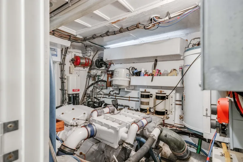 Slide: The Image of Engine room of 1980 Hatteras 53 Motor Yacht, showcasing mechanical components and piping. - 28
