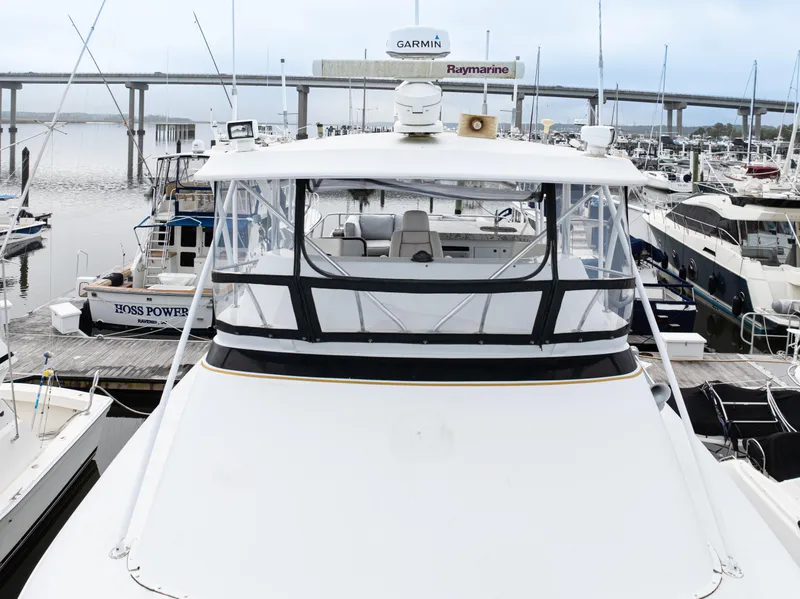 Slide: The Image of 1980 Hatteras 53 Motor Yacht docked at marina, featuring spacious deck and bridge. - 49