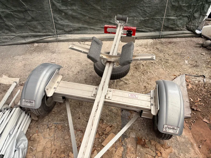 Slide: The Image of Trailer for 2012 15-ft Adirondack Guideboat, parked on gravel with tarp background. - 12