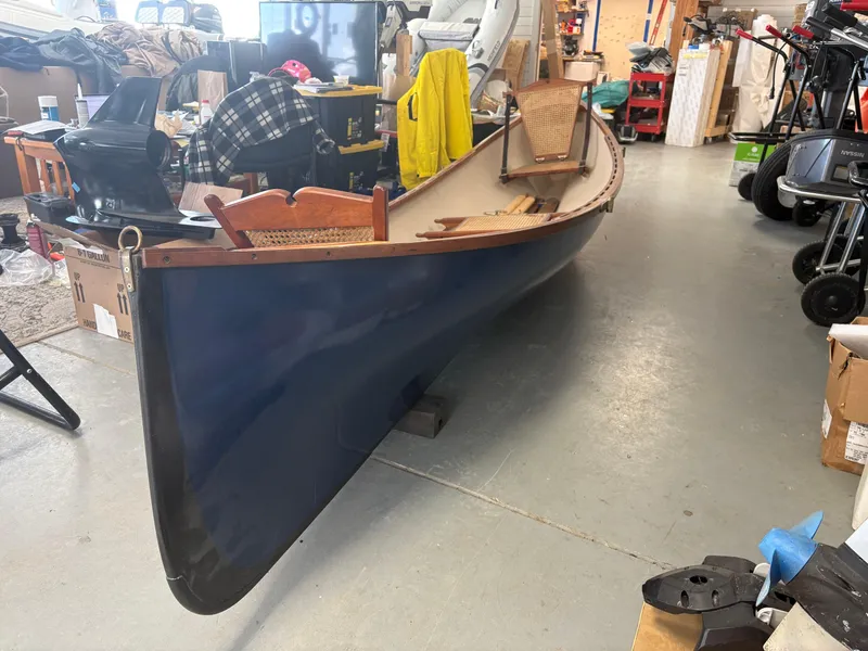 Slide: The Image of 2012 15-ft Adirondack Guideboat in a garage, featuring a sleek blue hull. - 4