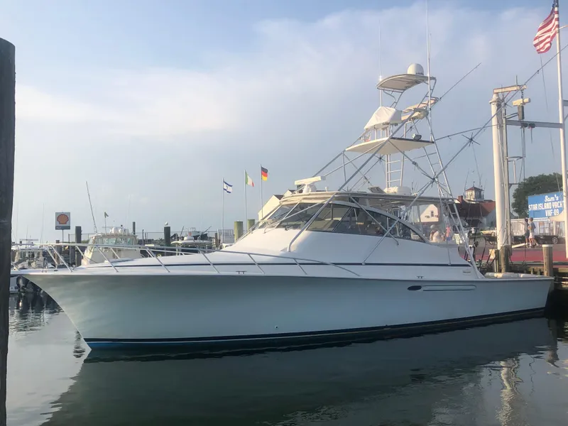 Slide: The Image of 1998 Ocean Yachts 48 Express docked at marina, clear sky background. - 10