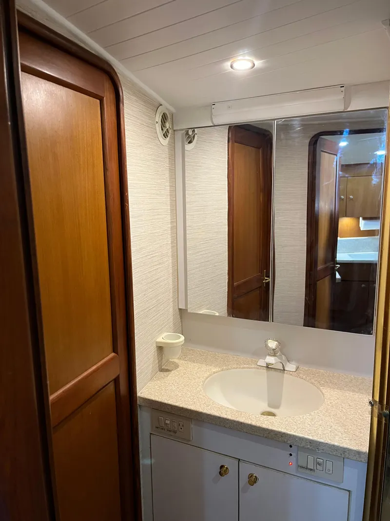 Slide: The Image of 1998 Ocean Yachts 48 Express bathroom with wooden door, mirror, and sink. - 8