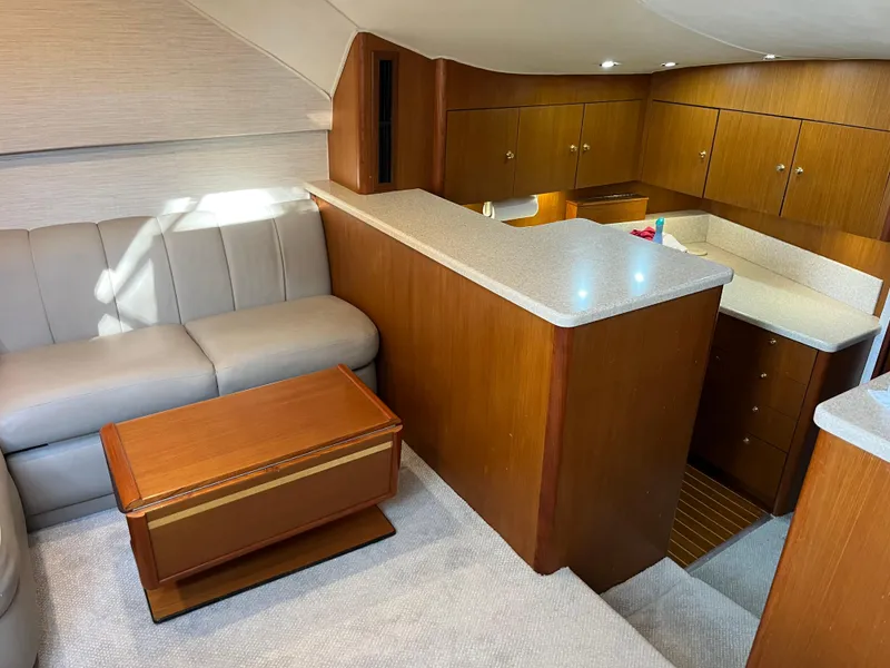 Slide: The Image of Interior of 1998 Ocean Yachts 48 Express with cozy seating and wooden cabinetry. - 4