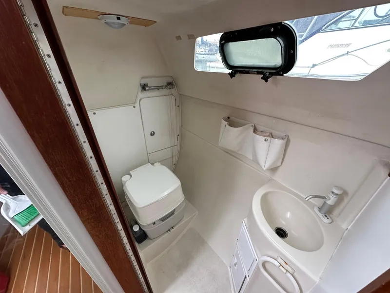 Slide: The Image of Interior of 2005 Catalina 250 MkII boat bathroom with toilet, sink, and porthole window. - 12