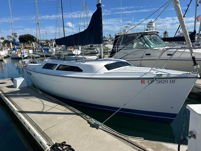 Slide: The Image of 2005 Catalina 250 MkII sailboat docked in a marina under clear skies. - 2