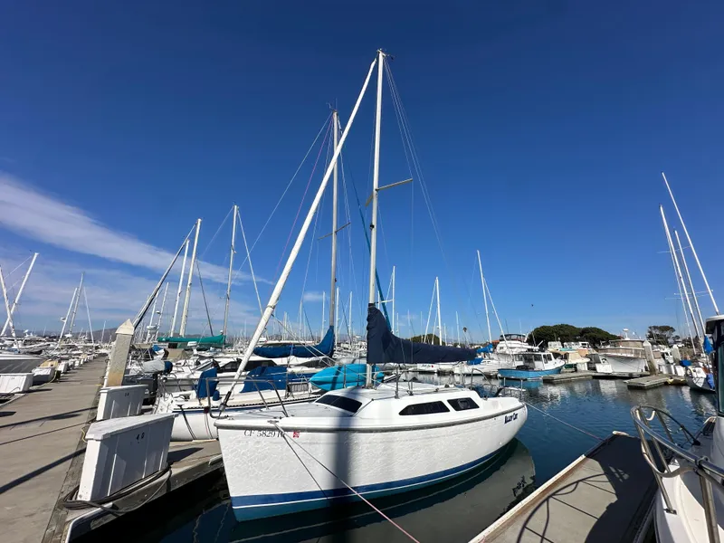 Slide: The Image of 2005 Catalina 250 MkII sailboat docked in a marina under clear blue skies. - 3