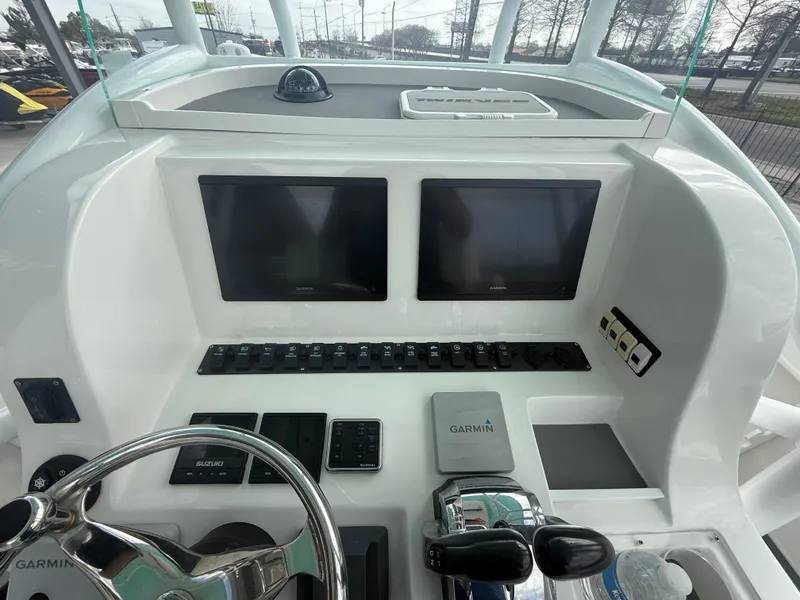Slide: The Image of 2021 Twin Vee 310 GF boat dashboard with dual Garmin screens and controls. - 18