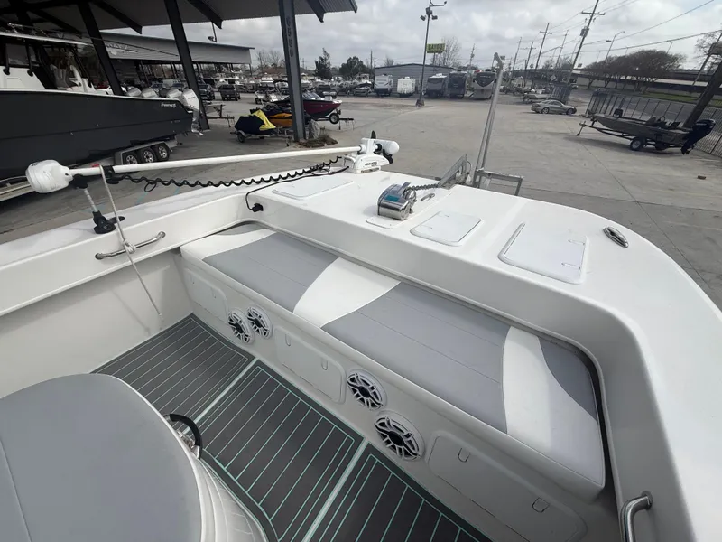 Slide: The Image of 2021 Twin Vee 310 GF boat interior with seating and speakers, docked at a marina. - 20
