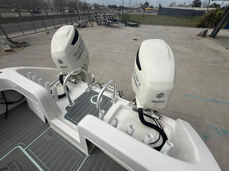 Slide: The Image of 2021 Twin Vee 310 GF boat with dual Suzuki 300 engines, docked on concrete. - 22