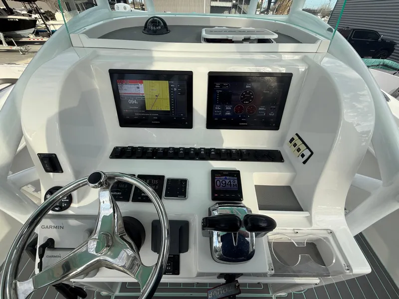 Slide: The Image of 2021 Twin Vee 310 GF boat dashboard with dual screens and steering wheel. - 23