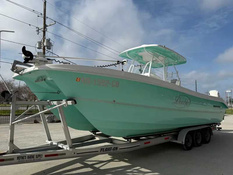 Slide: The Image of 2021 Twin Vee 310 GF boat on trailer, light blue hull, parked outdoors. - 7