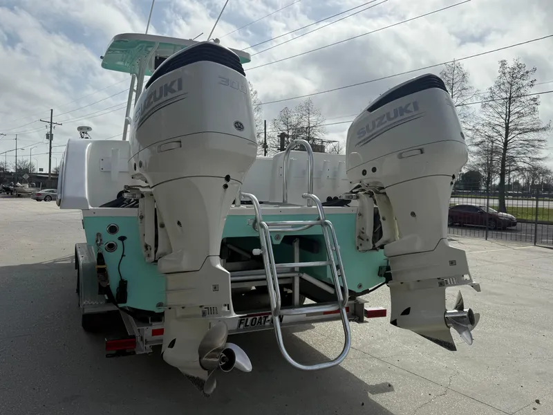 Slide: The Image of 2021 Twin Vee 310 GF boat with dual Suzuki outboard motors, parked on a trailer. - 9