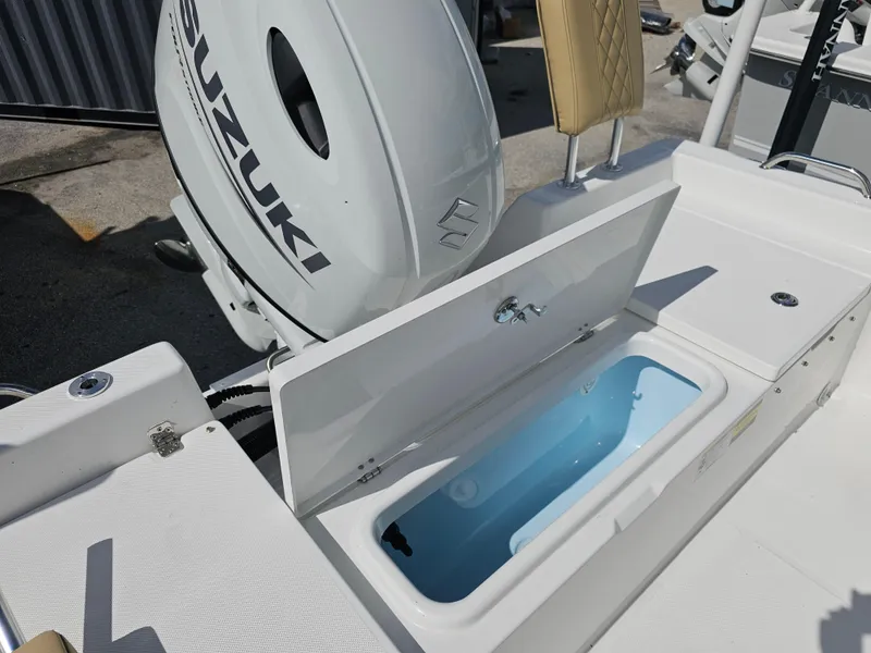 Slide: The Image of 2025 Savannah 210X boat with Suzuki outboard motor and open storage compartment. - 17