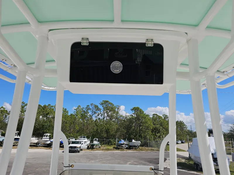 Slide: The Image of T-top of 2025 Savannah 210X boat with clear sky and parked boats in background. - 22